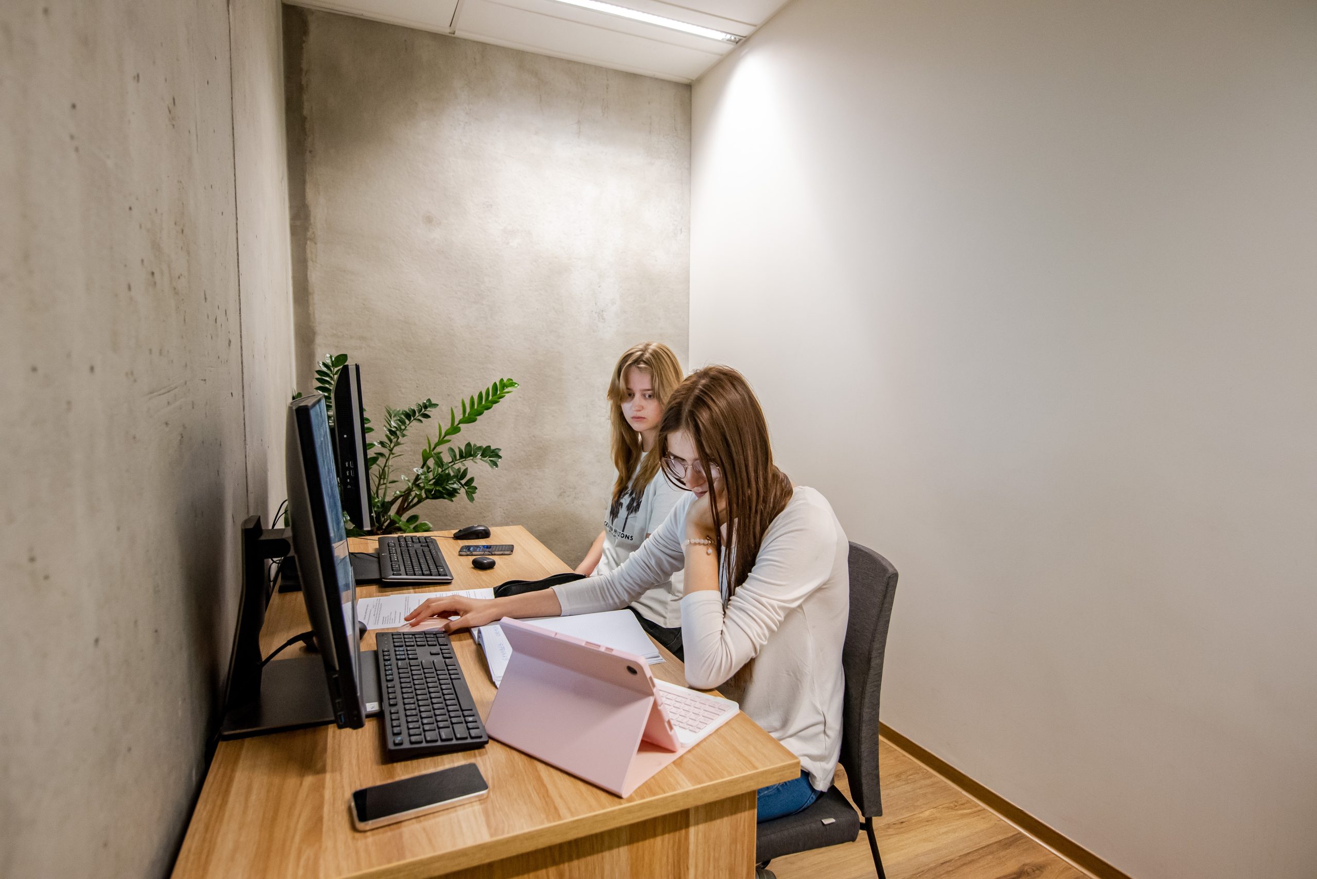 Studentės sėdi bibliotekoje